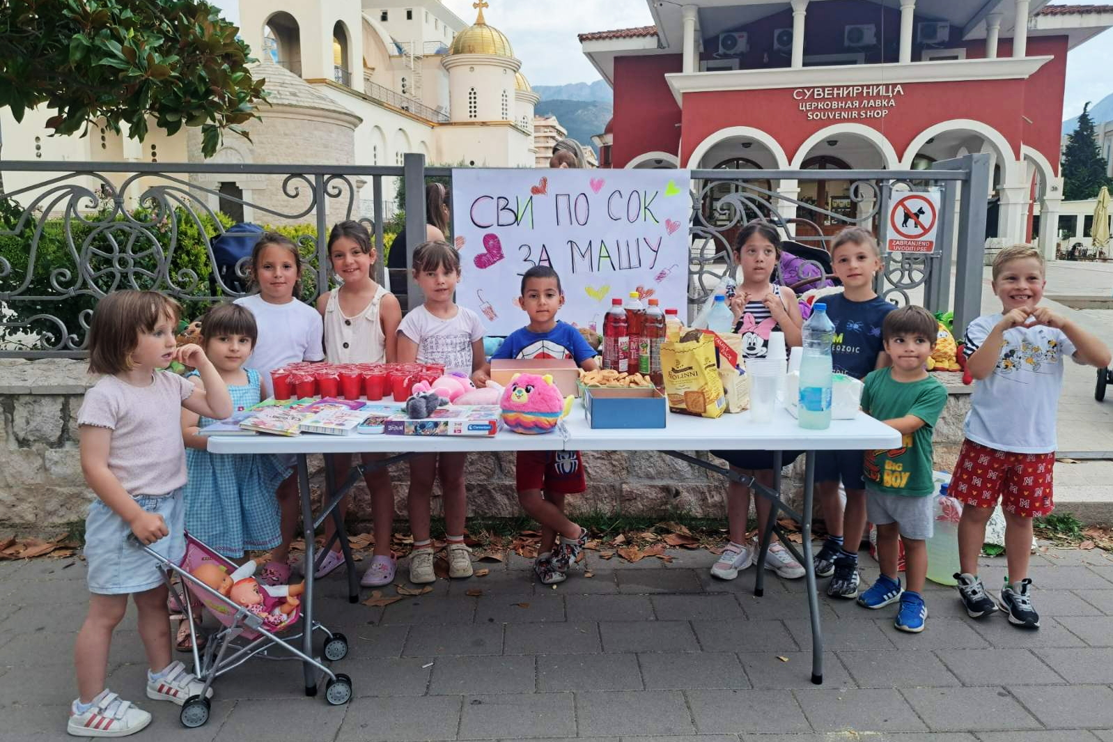 You are currently viewing Сјутра након Свете Литургије испред саборног храма Светог Јована Владимира: „Сви по сок за Машу!“